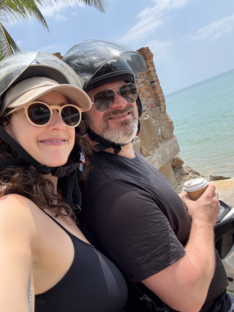 Ali and Gab on a scooter by the ocean